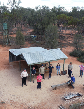 Aerial view of Earthwatch Fellows (high school students) standing near corrugated iron lean-to shelter
