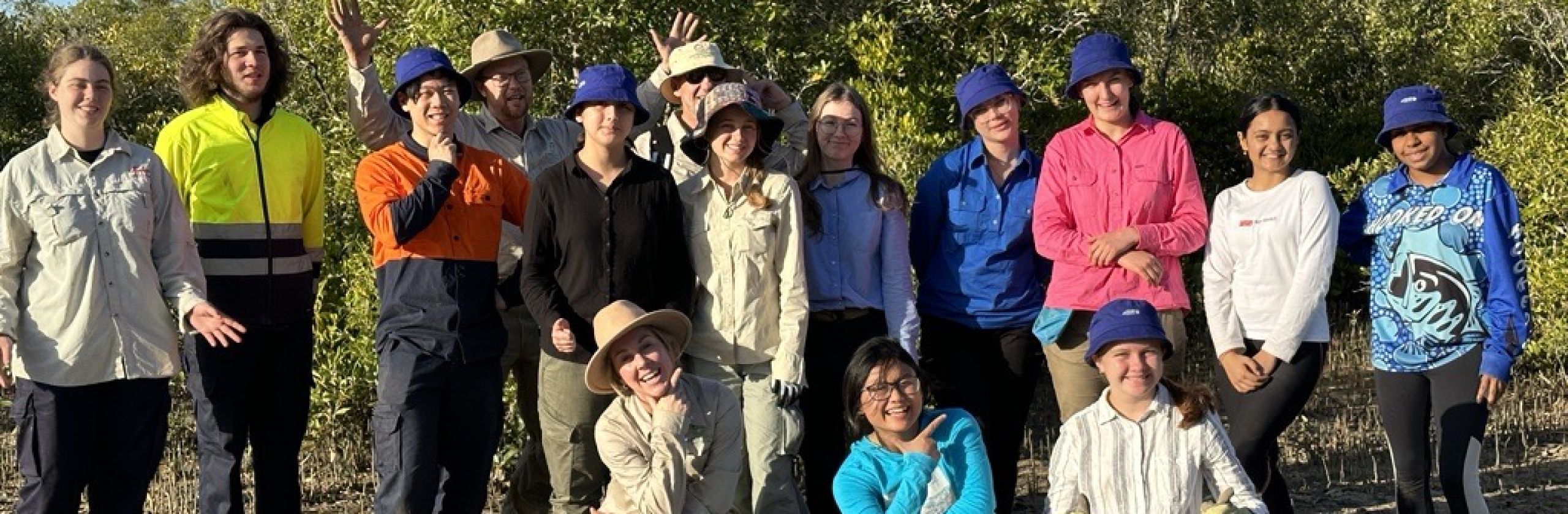 Earthwatch Student Challenge fellows on the expedition 'Protecting the reef's coastal frontier'. A group of young people standing together with mangrove forest behind them. 