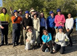Earthwatch Student Challenge fellows on the expedition 'Protecting the reef's coastal frontier'. A group of young people standing together with mangrove forest behind them. 
