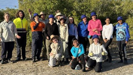 Earthwatch Student Challenge fellows on the expedition 'Protecting the reef's coastal frontier'. A group of young people standing together with mangrove forest behind them. 