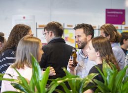 A group of students talking to each holding drinks
