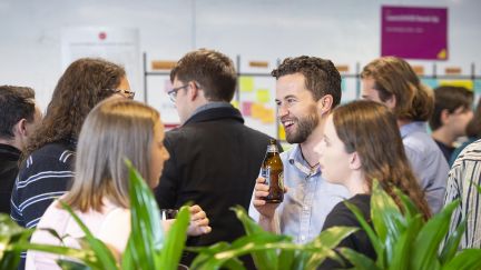 A group of students talking to each holding drinks