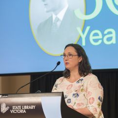Alumna Benda McKinty standing at lectern