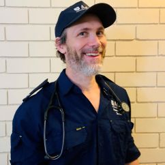 Andrew McLeod-Warner, ACU scholar. Man in paramedic uniform smiling.