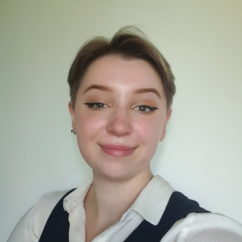 Headshot of woman with short hair wearing a white shirt and smiling.