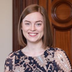 Hannah Webb, ISSI fellow. Smiling woman with shoulder length red hair.