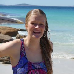 Samantha Crisp, James Cook University scholar. Young blonde woman smiling, the ocean in the background.