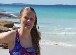 Samantha Crisp, James Cook University scholar. Young blonde woman smiling, the ocean in the background.