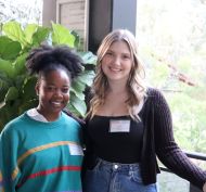 Two women posing in front of camera.