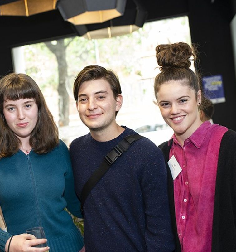 Three young students smiling.