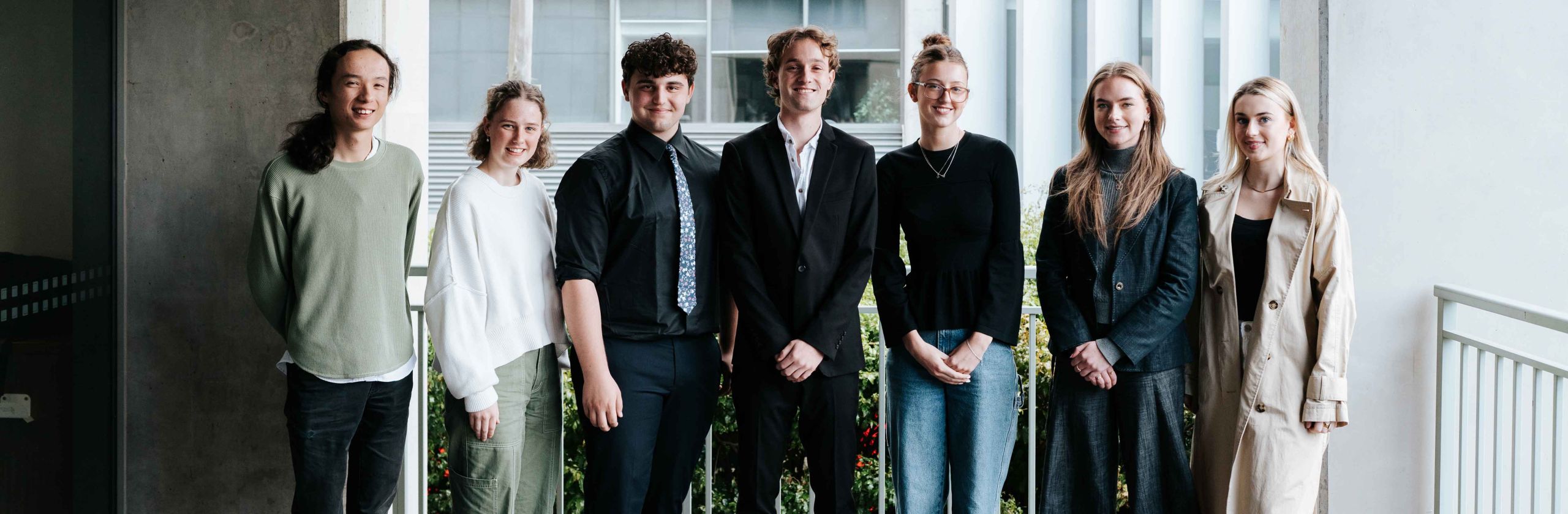 A group of university students standing in a group outside. 