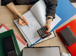 Aerial view of a person holding a calculator and looking at documents