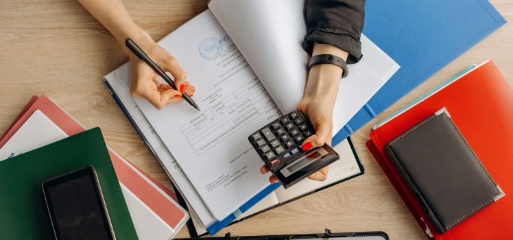 Aerial view of a person holding a calculator and looking at documents