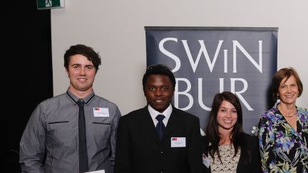 A group of yougn students standing in front of Swinburne sign