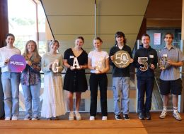Murdoch GAF scholars lined up smiling while holding photo props that spell out GAF 50
