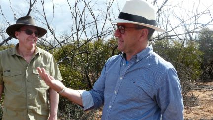Two men in bush scrub area