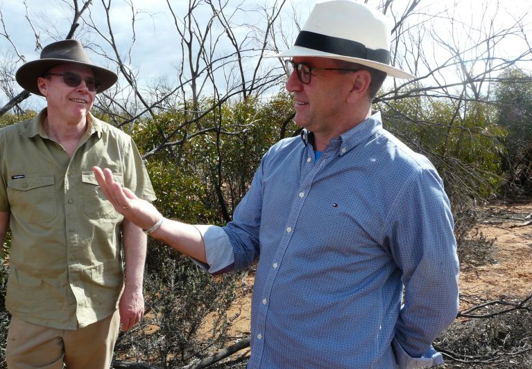 Two men in bush scrub area