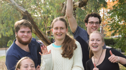 A group of 5 young students smiling