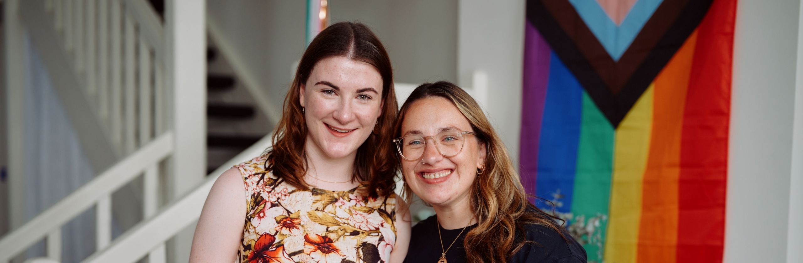Two young women side by side smiling at camera.