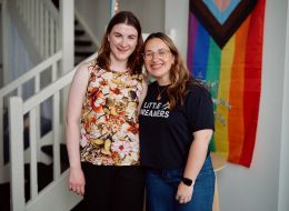 Two young women side by side smiling at camera.
